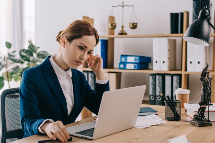 female-lawyer-in-suit-working-on-laptop-at-workpla-3KSJ2Q9.jpg